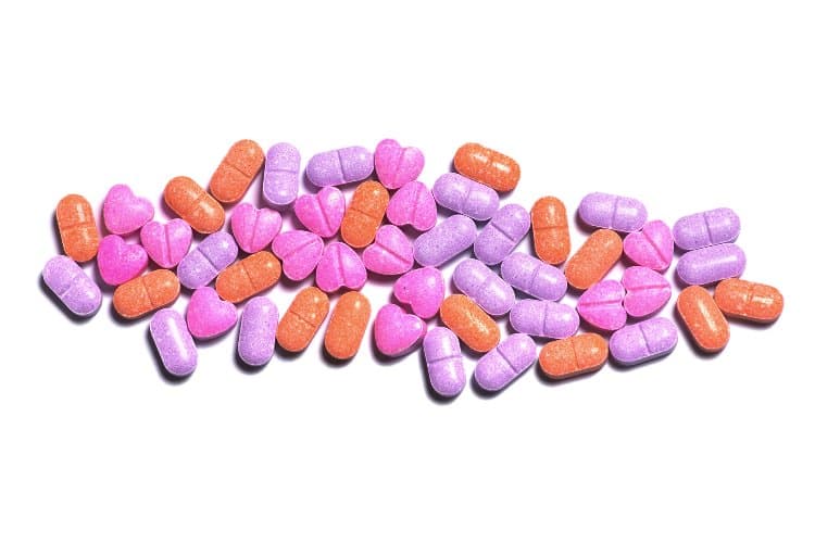 Closeup shot of a pile of colorful pills on white background.