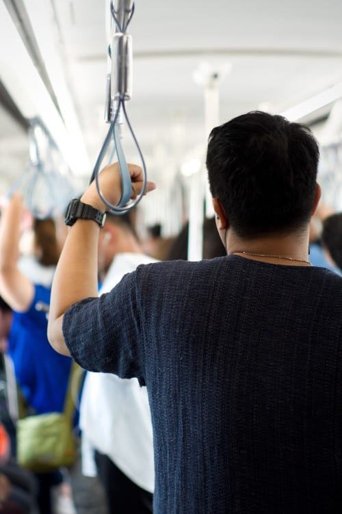 man standing on crowded subway train