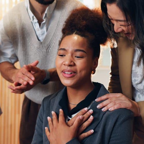 woman being comforted by group