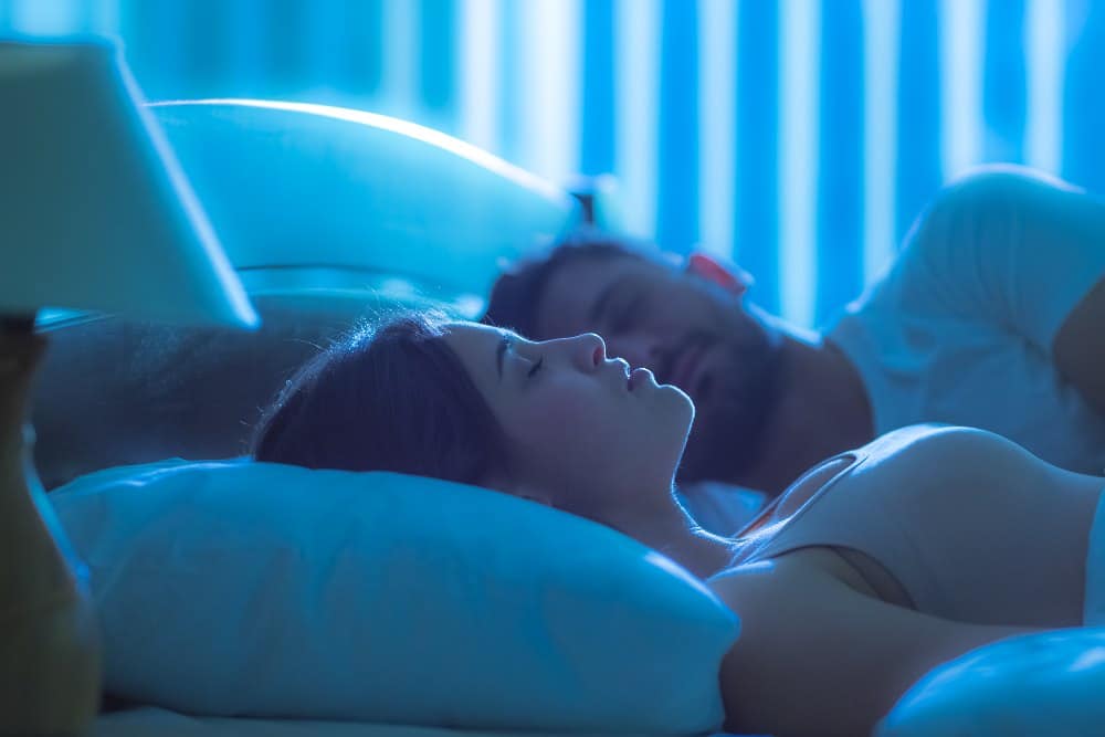 The woman sleeping near the man in the bed